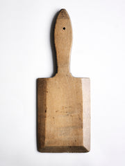 A charming vintage mini butter paddle board with handle and hanging hole, which makes an excellent board for the serving of a block of butter or wedge of cheese. It has a ridged surface on one side, and a beautiful time-worn surface with wonderful patina and chamfered edge on its reverse side; and when not in use, looks great when hung or propped up on the kitchen side.