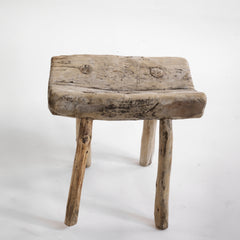 An antique primitive wooden stick stool, the top crafted from a single section of trunk.
