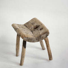 An antique primitive wooden stick stool, the top crafted from a single section of trunk.
