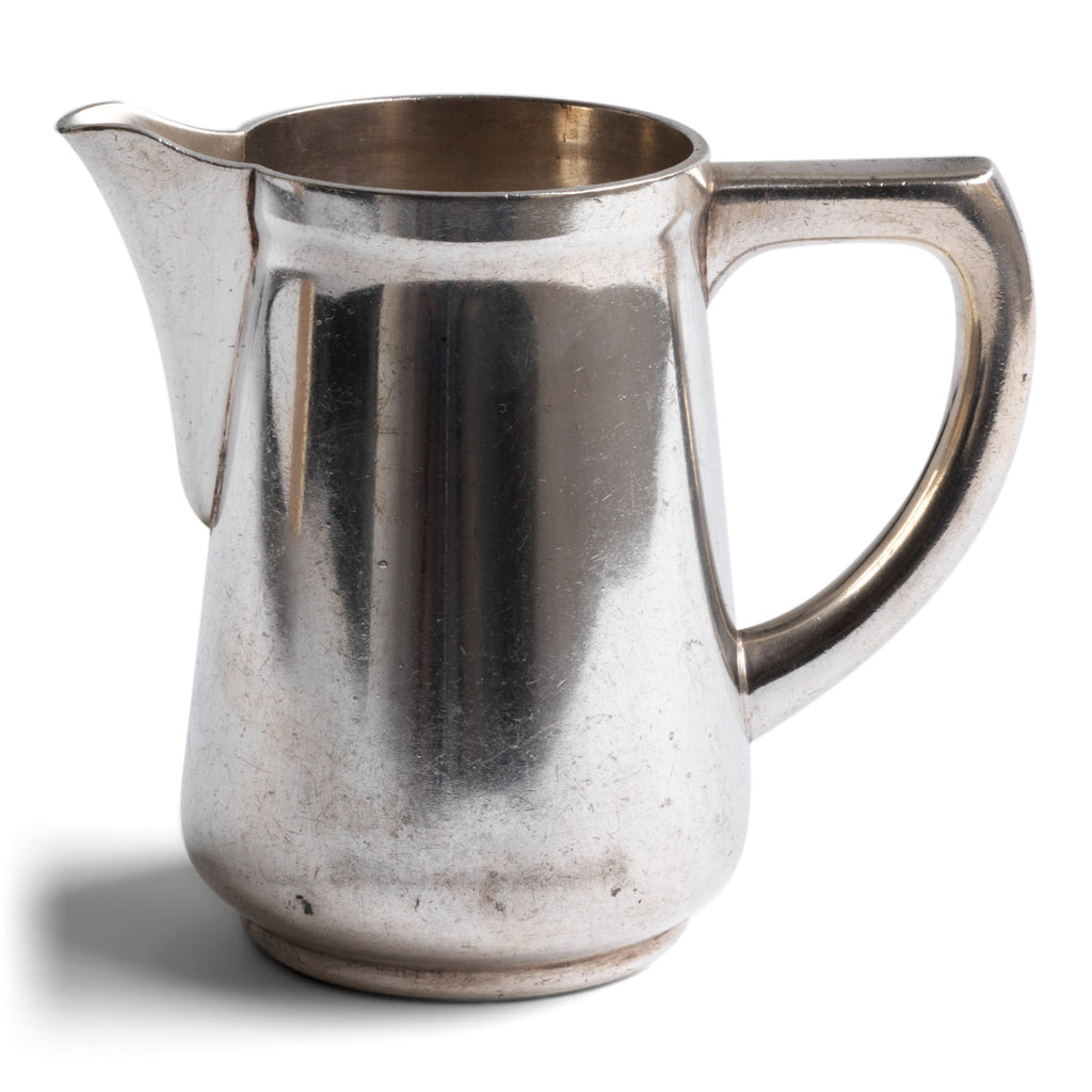 A good, heavy-duty German WMF silver plated milk jug stamped "Wurtt Metall W Fabrik", an abreviation for Württembergische Metallwarenfabrik ( Württemberg metal factory), and "Geislingen Steig", the southern German town where the factory was based.  It also bears an arrow mark, indicating it was for military use - and was most probably made for an English officer's mess.