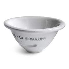 An Edwardian ironstone egg separator, with “Lightning Egg Separator” typeface. Egg separators are small round cups with a slot on one side, and were part of the ironstone creamware batterie de cuisine of the late 19th century kitchen.
