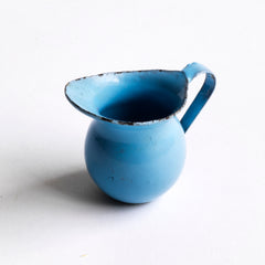 A miniature enamel jug, part of an extensive collection of pale blue enamel miniature antique kitchen ware, previously owned by the miniaturist specialist and collector extraordinaire Joan Dunk; including, flour scoops, sieve, ewer, grater, saucepan, frying pan and a funnel.