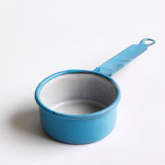 A miniature blue enamel saucepan, part of an extensive collection of pale blue enamel miniature antique kitchen ware, previously owned by the miniaturist specialist and collector extraordinaire Joan Dunk; including, flour scoops, sieve, ewer, grater, saucepan, frying pan and a funnel. 
