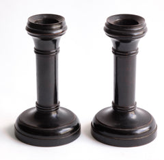 A handsome pair of Edwardian ebony candlesticks, their shape reminiscent of the castles in a game of chess.