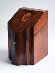 A very handsome George III mahogany veneered knife box with flower basket oval inlay on the slope of its lid. The serpentine front is banded in satinwood, and it has a compass star decoration with rope cross-banded inlay applied to the underside of its lid. The base is felt baize covered, and it has a copper escutcheon and matching lid pull.