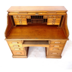 A magnificent and high quality Edwardian golden oak tambour-front writing desk, with fitted interior, and solid oak fielded (bevelled) panelled sides and back. Each pedestal has four fitted graduated drawers, and at the top, two brush slides: desk extension pull-out ledges.