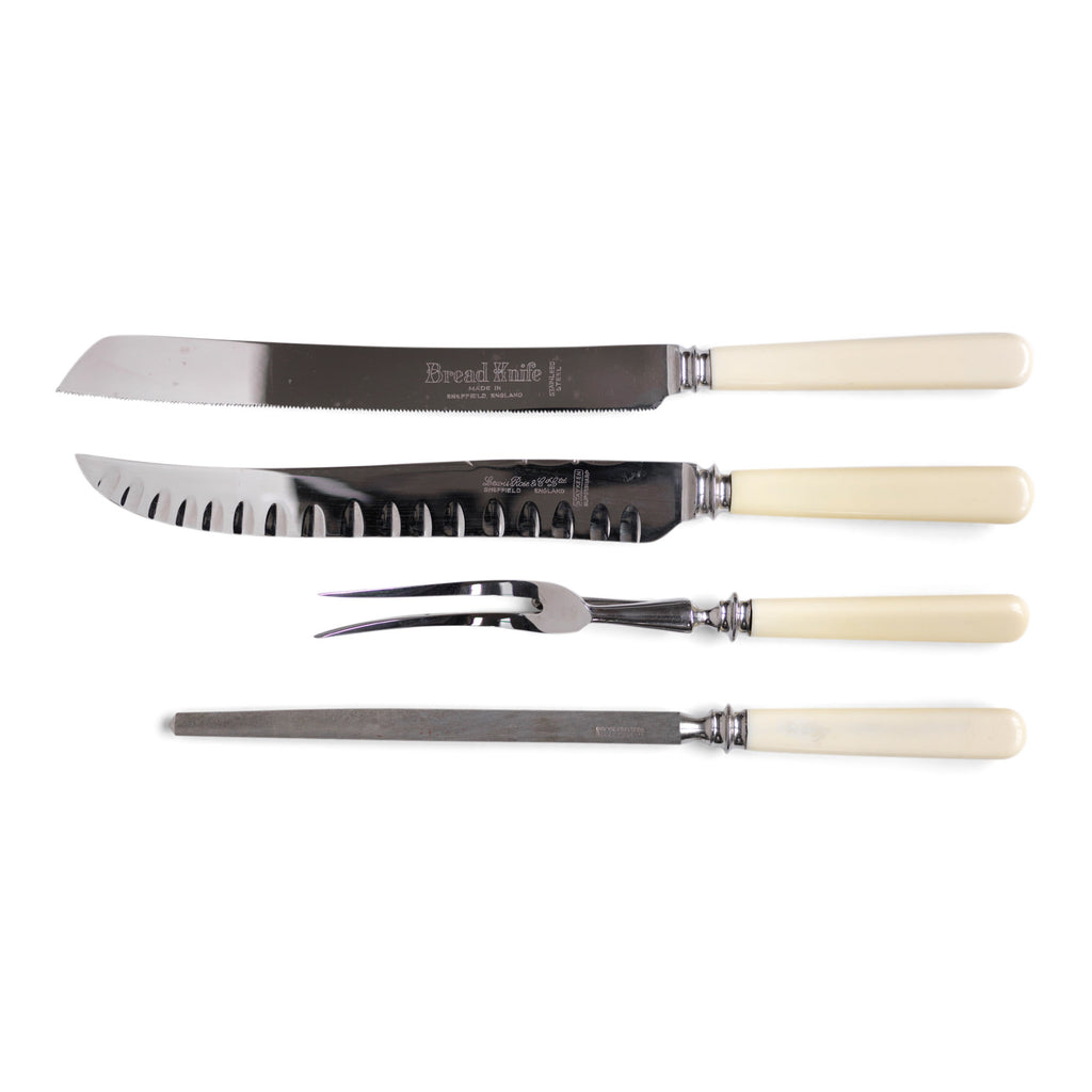 A four piece 'bone-handle' carving set by Lewis Rose & Co Ltd Sheffield, consisting of a carving knife and fork, a sharpening steel, and a matching bread knife: and in such pristine condition, it looks like this set has never been used. Carving knife, fork and bread knife have ivorine handles fashioned from xylonite.