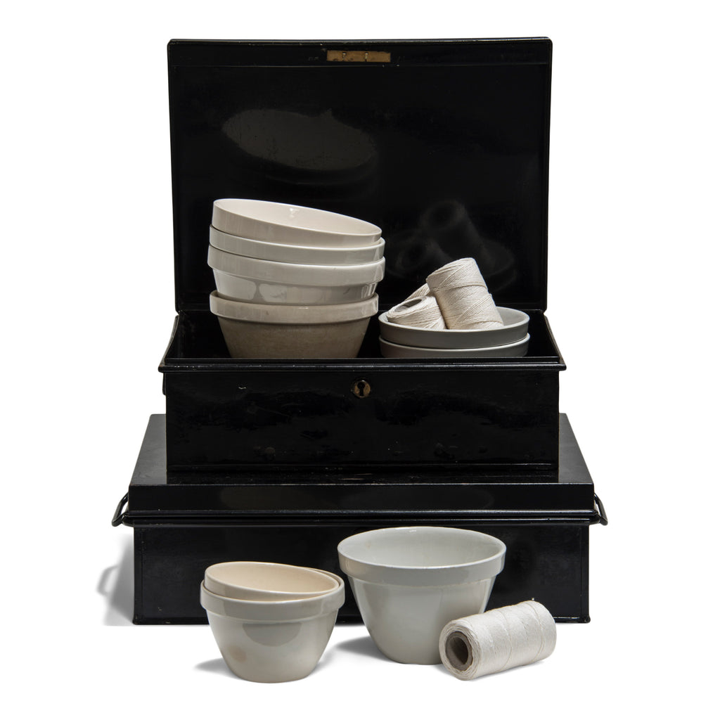 A pair of beautifully proportioned antique Edwardian document tins with their original black laquer paint finish; a collection of old-school vintage ceramic ironstone and creamware pudding bowls, dating from the mid to late twentieth century; and spools of kitchen trussing twine, made from spun flax.
