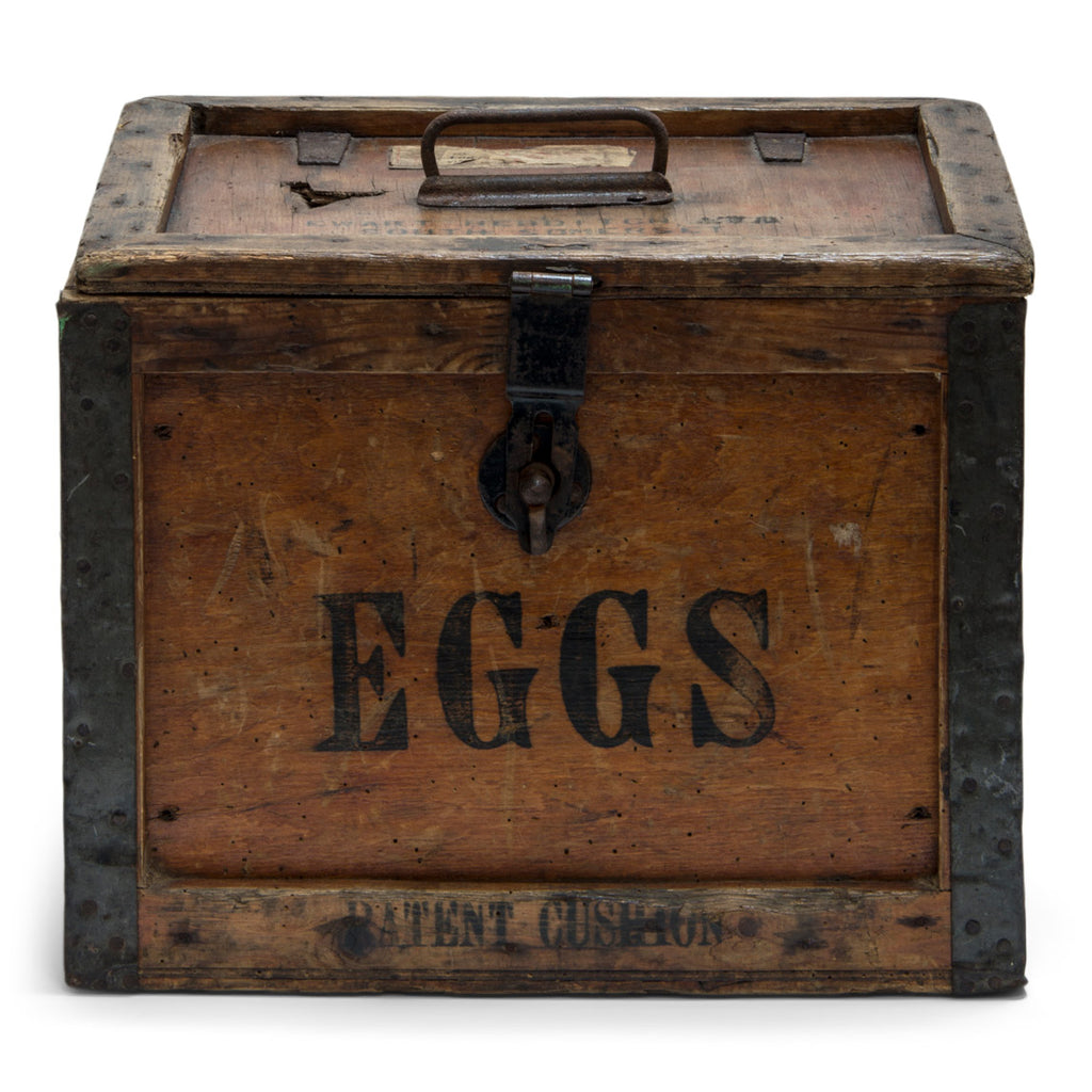 A 1920s egg travelling box, once used at Ewart Hebdish South Somerset Poultry Farm, Martock, Somerset, UK - as stamped on the lid. All four side panels and the lid are stencilled "Eggs", and various extra stamps, as shown in the images.  It has a bracket hinged lid with carrying handle, reinforced metal trim corners, and a hasp. Inside the lid it still has its original maker's paper label, applied by the "Dairy Outfit Company Ltd, Kings Cross, London N1"