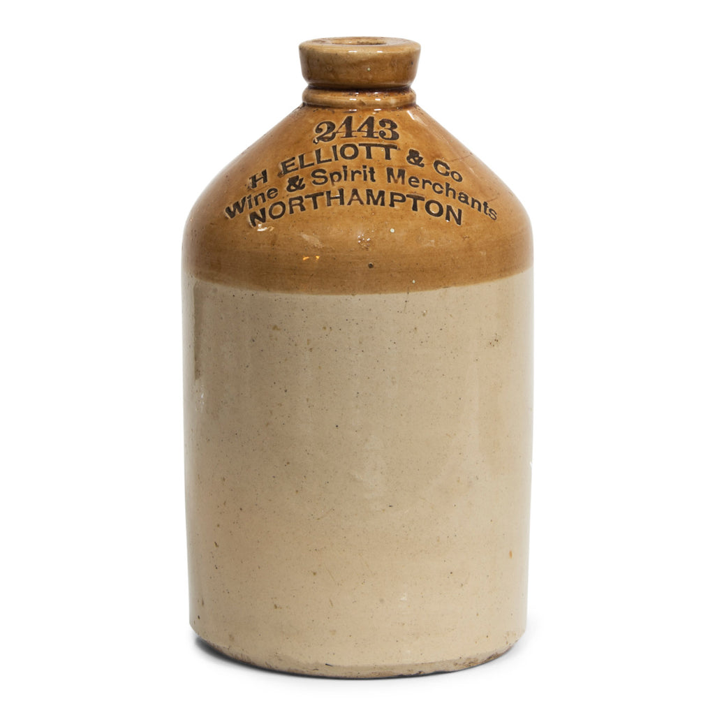 An early Victorian flagon with strap handle and bold incised nineteenth century typeface: " 2443 H Elliot & Co Wine & Spirit Merchants Northampton". I