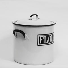 A handy-sized black and white enamel flour bin with original lid and striking "Flour" typeface encased in a double rectangular border.