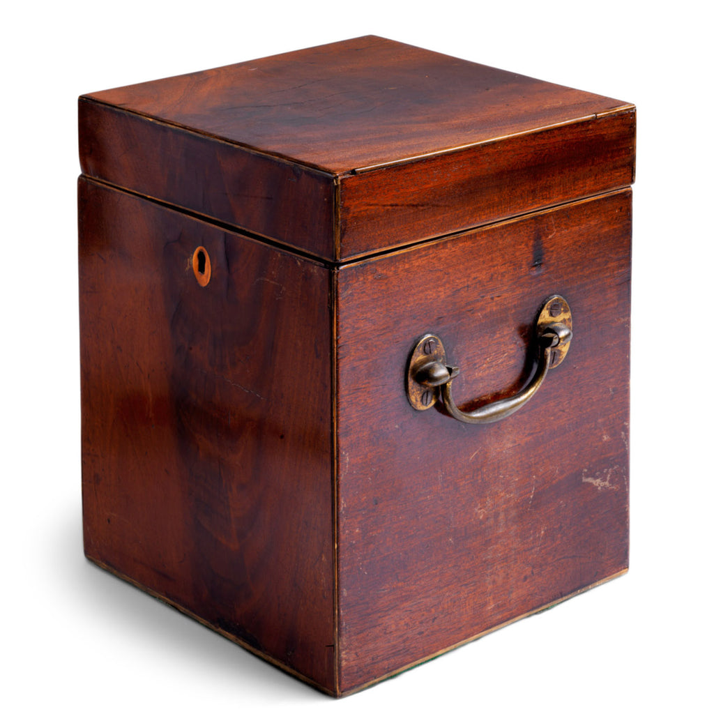 A handsome George III mahogany veneered butler's wine chest or cellaret with hinged lid; having veneer strung edges, twin brass carrying handles, felt baize covered underside, and an oval shaped veneer escutcheon. Originally it would have been lined inside and had wooden divisions, diving the inside into four - to house four bottles or decanters. 