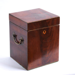 A handsome George III mahogany veneered butler's wine chest or cellaret with hinged lid; having veneer strung edges, twin brass carrying handles, felt baize covered underside, and an oval shaped veneer escutcheon. Originally it would have been lined inside and had wooden divisions, diving the inside into four - to house four bottles or decanters. 