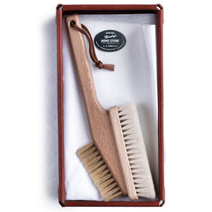 A computer cleaning brush with a long wooden handle and two types of bristles, soft and stiff, for cleaning laptops and other office equipment.