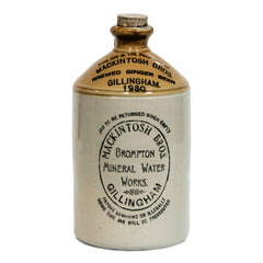 A handsome 1930s flagon with strap handle, original stopper, and bold utilitarian typeface: "This jar is the property of Mackintosh Bros Brewed Ginger Beer Gillingham 1930.