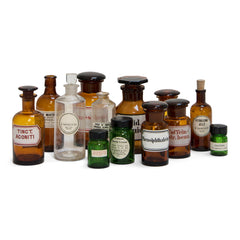 A large collection of early twentieth century pharmacy bottles, in amber, clear and green glass. There are 13 in in total and all are with their original labels - some are from D Davies & Co, Caledonian Road, London N1.