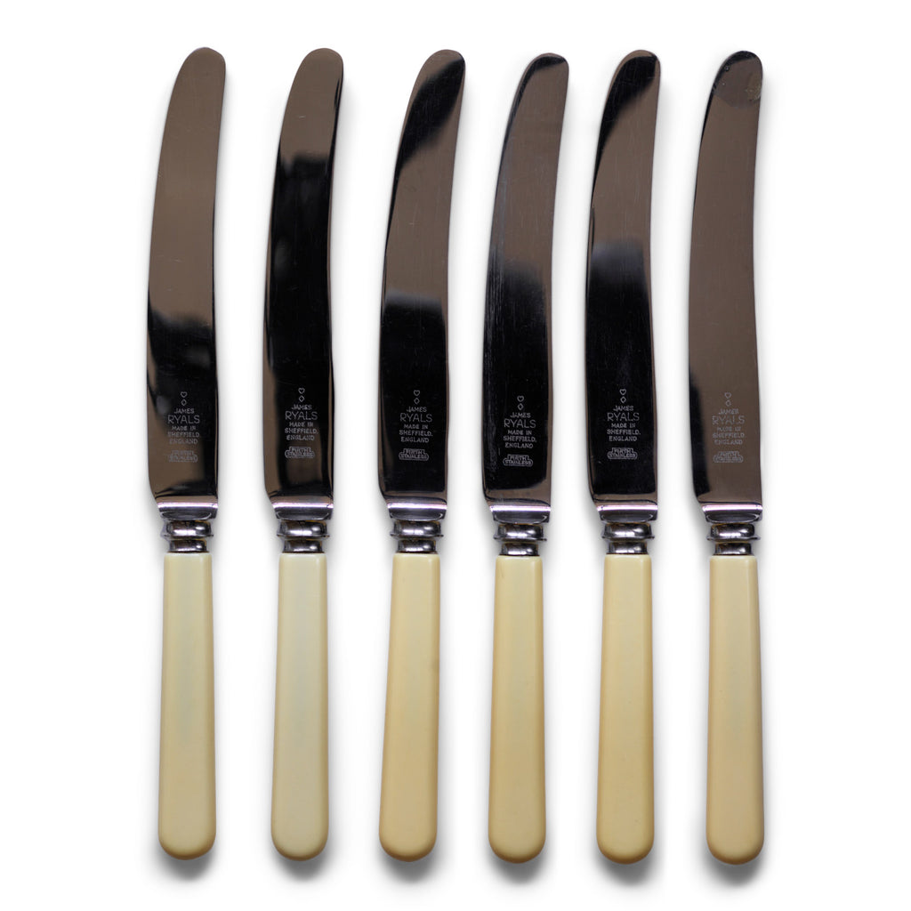 A set of 6 dinner knives, each blade marked "James Ryals & Co Ltd", and each in its original paper sleeve - and never used.