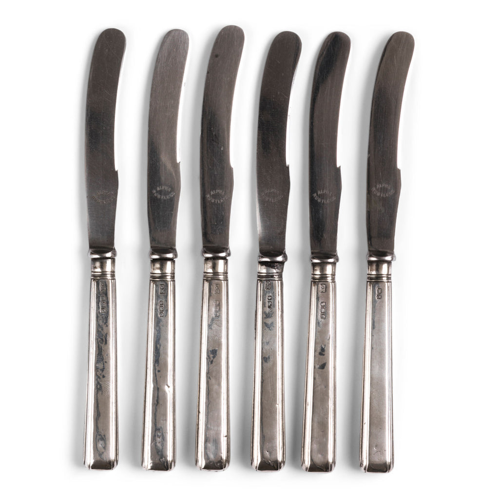 A set of 6 antique George V butter knives with solid silver reed border handles and stainless steel blades. Each handle is hallmarked with a lion which denotes its Sterling silver credentials, and with GH - which stands for Harrison Brothers & Howson, Sheffield. Further hallmarks date them as made in 1919.
