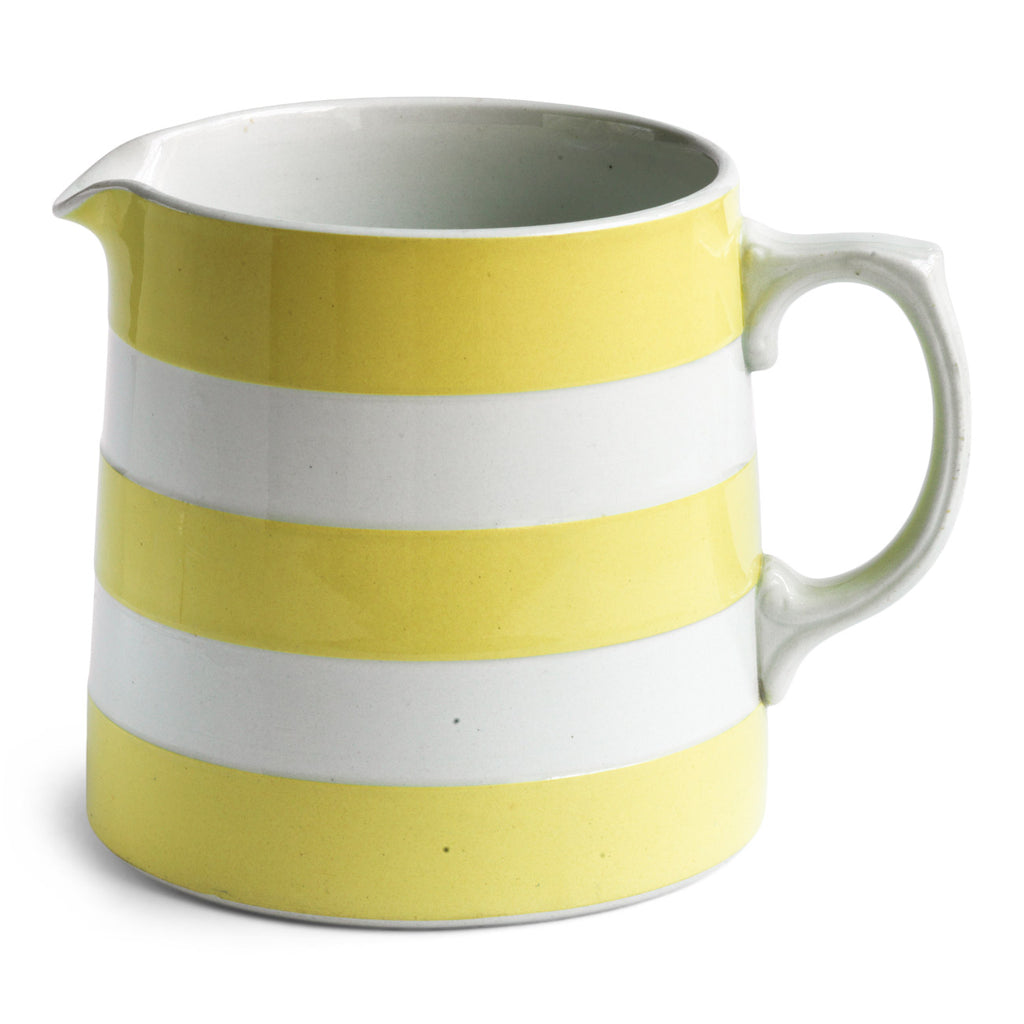 A T G Green yellow banded Cornish Ware milk jug has a green shield stamp to its underside which dates it to c.1930.
