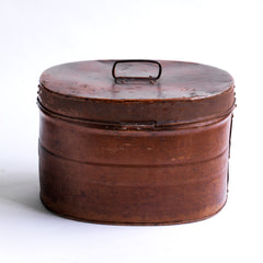 A handsome Victorian hat tin with hinged lid, carrying handle, hasp, and original pecan brown painted finish. The interior paint is also original and is a steely Prussian blue. It has a wonderful polished and buffed patina, built from its 130 years of travels.