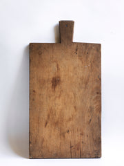 A rustic antique vintage chopping board with a time-worn, knife-cut patina, full of character and warmth.
