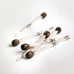 A rare set of 1930s silver-plated nut picks designed to wheedle out every last nugget of flesh from a walnut shell - always the difficult nut to dissect. They have a wonderful weight and beautifully turned, polished handles with a miniature walnut modelled in wood at the end of each. 
