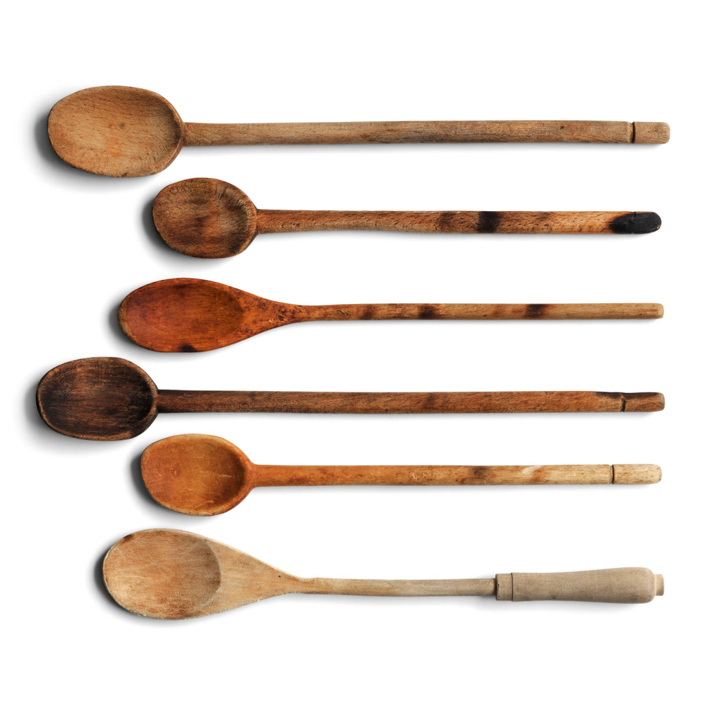 A collection of vintage wooden cooking spoons. Decades of use has given each its own beautiful patination, with a few scorch marks here and there, where the cook has left the spoon too close to the stove.