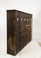 A magnificent bank of wooden lockers with original stained paint finish.  Each door is affixed with an oval aluminium numbered plate and name holder, and contains two circular air vents - top and bottom.  A grand looking and very handy storage solution for hallway, boot room or kitchen.