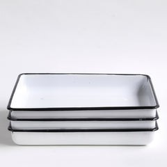 Three vintage white enamel trays, each with a black border. 